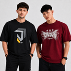 Two men modeling graphic t-shirts against a light gray studio background. The man on the left wears a black t-shirt with a gray and yellow geometric logo.